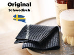 Original schwedische schwarze Spültücher auf grauem Teller mit Reinigungsbürste und Seifenflasche